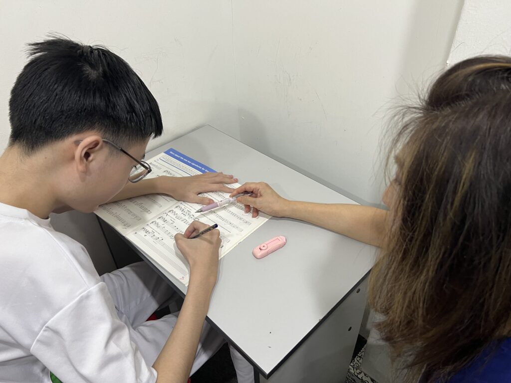 A student working through music theory with his teacher